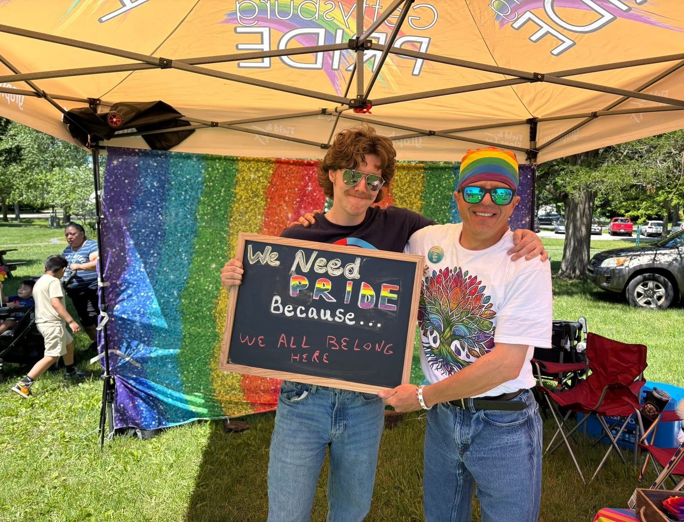 Two community members at Gettysburg Pride holding a sign reading 'We Need Pride Because... We All Belong Here'